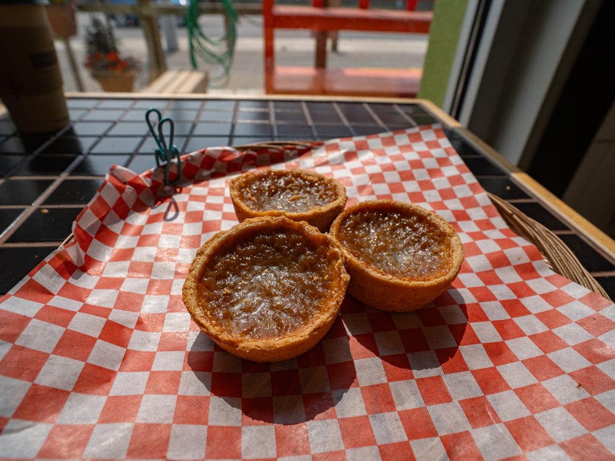 Butter tarts in paper cases on a wooden board